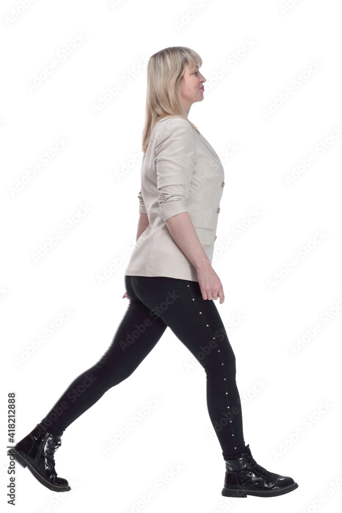 Fototapeta premium smiling woman in a white jacket striding confidently forward.