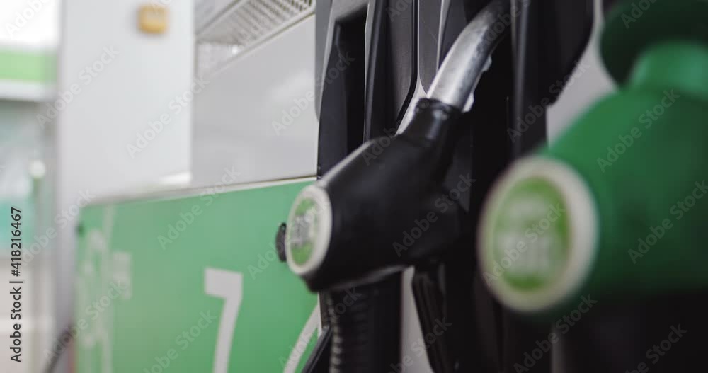 Close up of hand and fuel nozzle. Fuel nozzle getting put into its