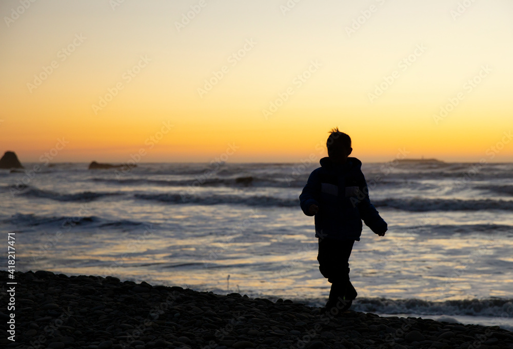 Young child walking the beach during sunset on the Washington Coast