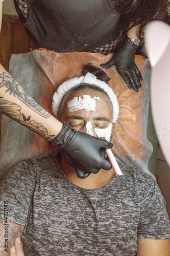 man receiving a facial in a beauty salon