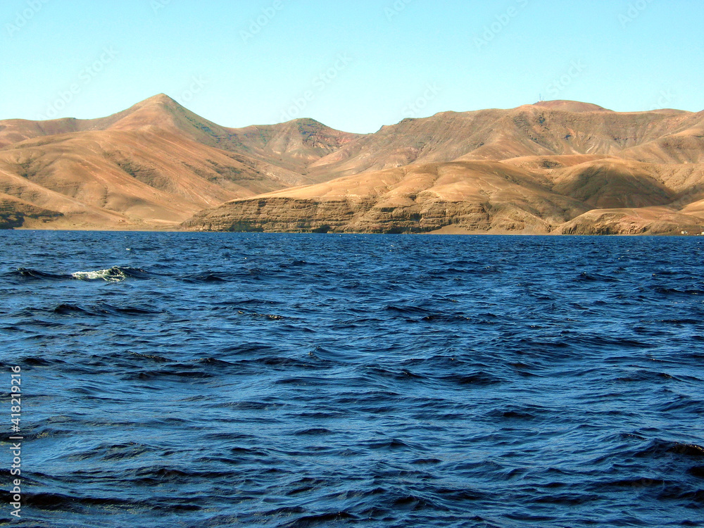 Volcanic hills on the coast of Lanzarote, Canary Islands, Spain; view from a boat.