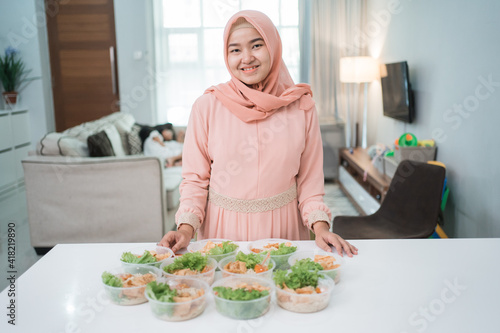 portrait of asian muslim woman food seller preparing her product at home kitchen