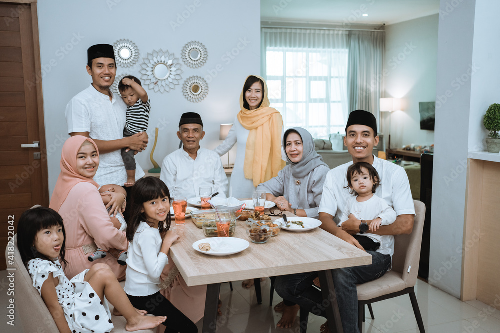 portrait of big asian muslim family on iftar dinner together smiling and looking at camera portrait of big asian muslim family on iftar dinner together smiling and looking at camera