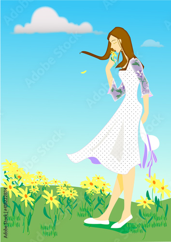 A girl who smells flowers in a blooming spring field and her hair fluttered in the wind