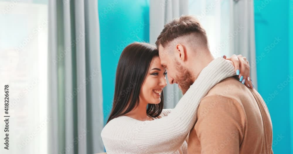 Smiling millennial man and woman touch foreheads hug spend romantic intimate tender weekend at home, happy young couple cuddle relaxing spending time together, relationships romance concept Smiling millennial man and woman touch foreheads hug spend romantic intimate tender weekend at home, happy young couple cuddle relaxing spending time together, relationships romance concept
