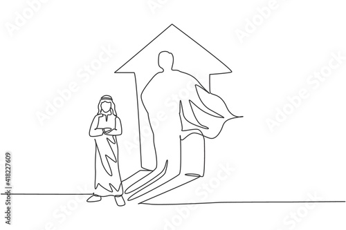 Single continuous line drawing of young Arabian businessman standing with super hero shadow on wall. Professional worker. Minimalism concept dynamic one line draw graphic design vector illustration