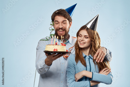 Emotional man with cake and pretty woman party disco blue background