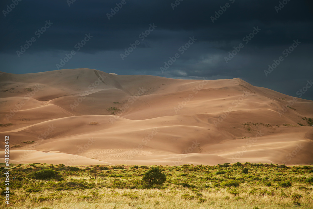 USA, Colorado, Great Sand Dunes National Park. Thunderstorm over sand dunes near sunset.