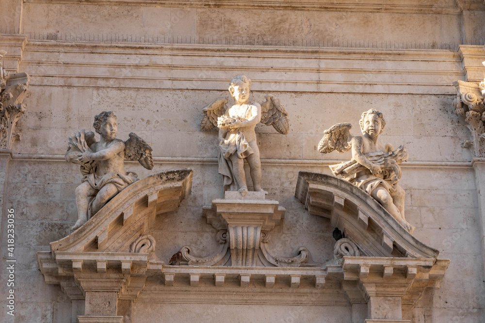 Marble statue of angles on porch in Dubrovnik old town in Croatia morning sunlight
