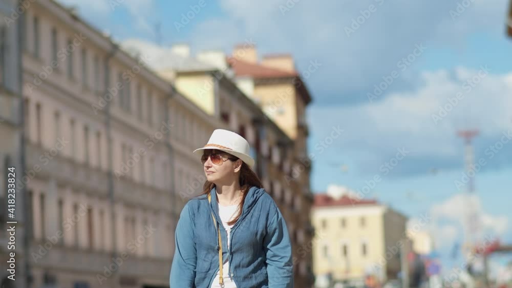 happy brunette woman travels around the city, woman in hat walking through the city happy brunette woman travels around the city, woman in hat walking through the city