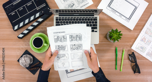 Top view of scriptwriter's workplace - laptop and storyboard with cup of coffee