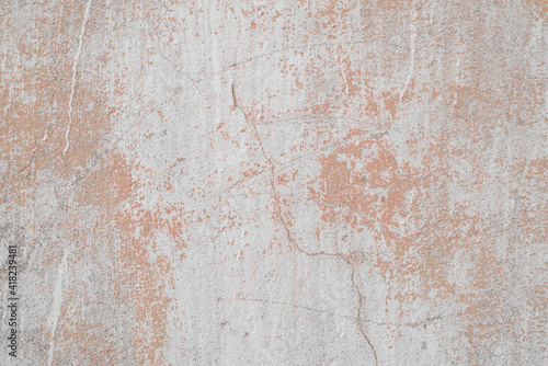 Texture of old concrete wall outside, close-up. Faded red paint, scratches, damage. © Sergio