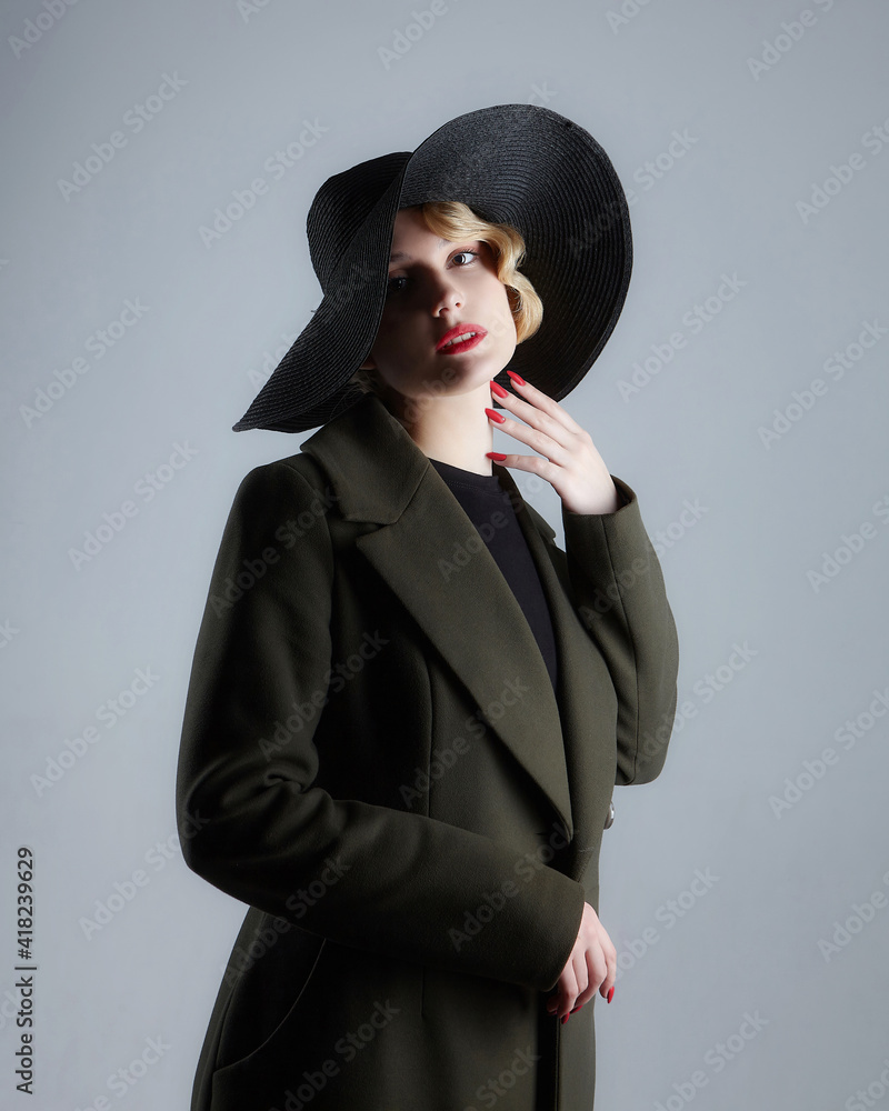 attractive blonde with a retro hairstyle in a black hat with a wide brim attractive blonde with a retro hairstyle in a black hat with a wide brim