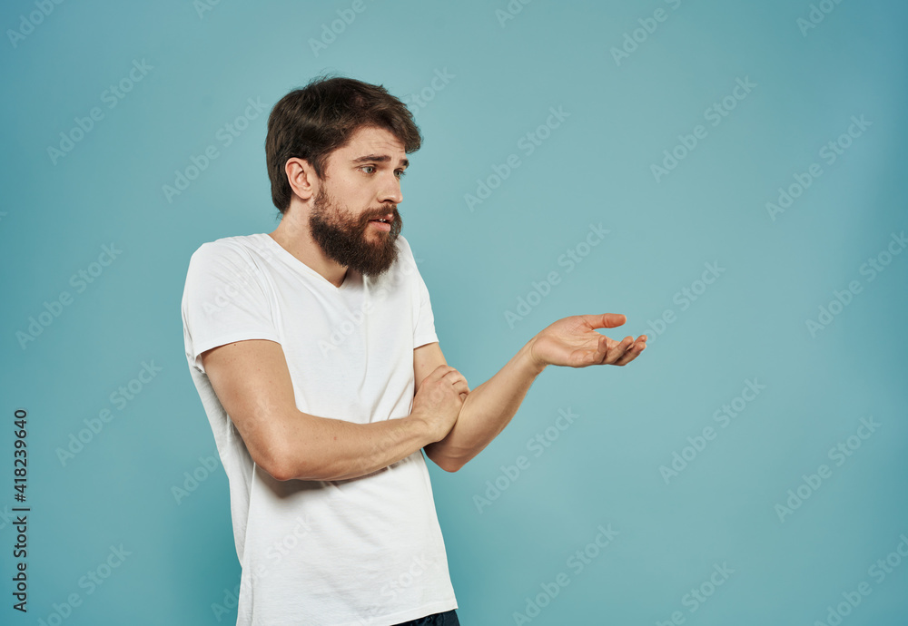 Indignant man gesturing with his hands on a blue background side view Indignant man gesturing with his hands on a blue background side view