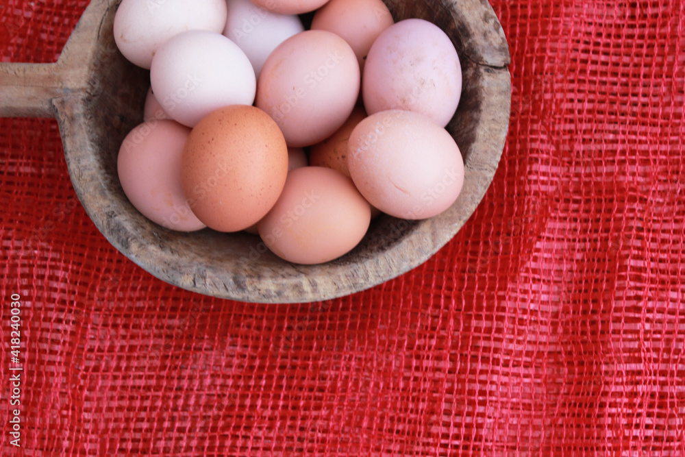 eggs in the wooden bowl and red nature background. Copy space for your text. eggs in the wooden bowl and red nature background. Copy space for your text.