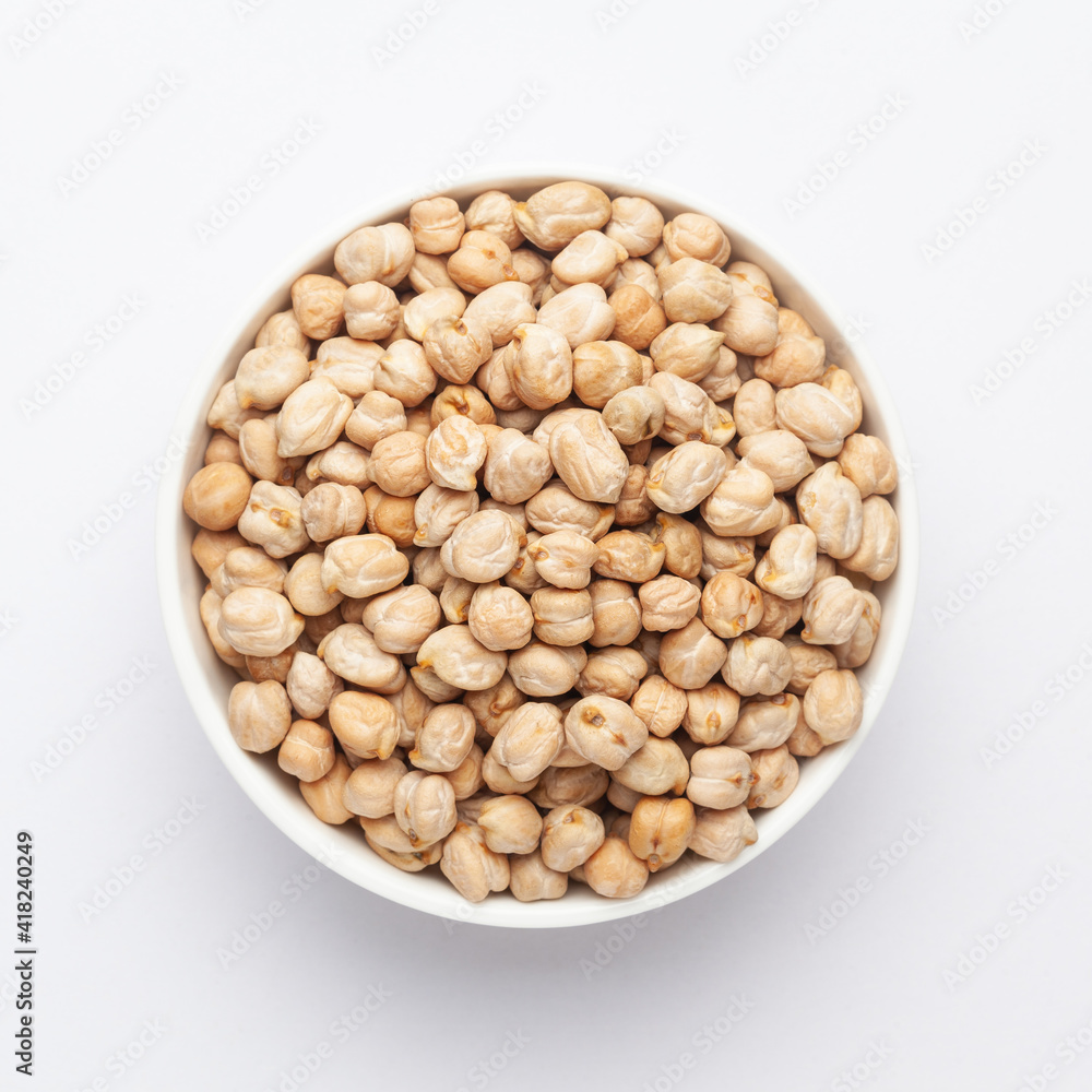 Close up of Organic chhole chana or Kabuli chana (Cicer arietinum) or whole white Bengal gram dal on a ceramic white bowl. Top view Close up of Organic chhole chana or Kabuli chana (Cicer arietinum) or whole white Bengal gram dal on a ceramic white bowl. Top view