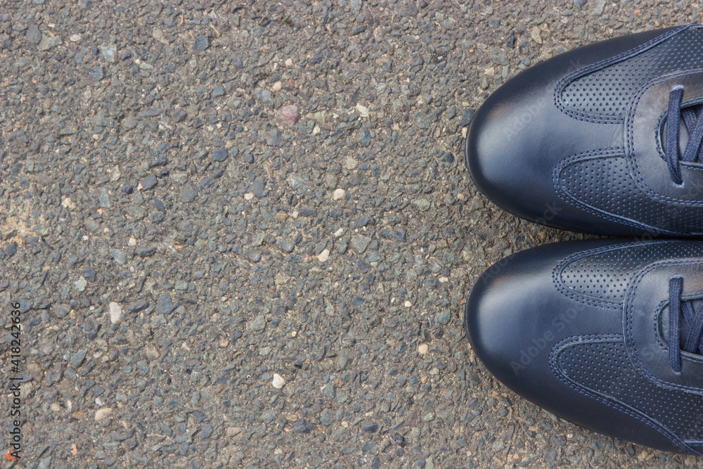 Navy blue leather shoes on asphalt road or footpath. Male footwear. Copy space for text
