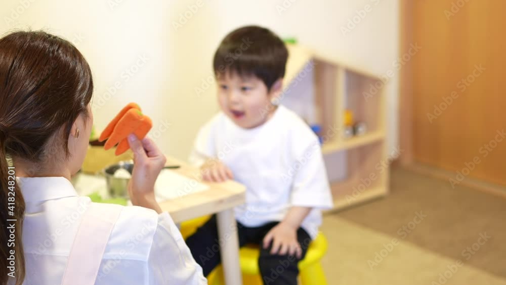 子供達と遊ぶ保育士の女性 子供達と遊ぶ保育士の女性