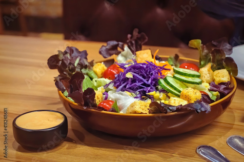 Mixed fresh vegetable salad with sauce on table, clean food concept with selective focus