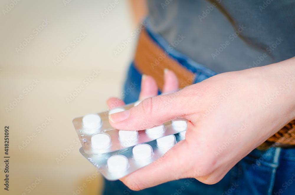 Medicines (tablets) in the girl's hand.