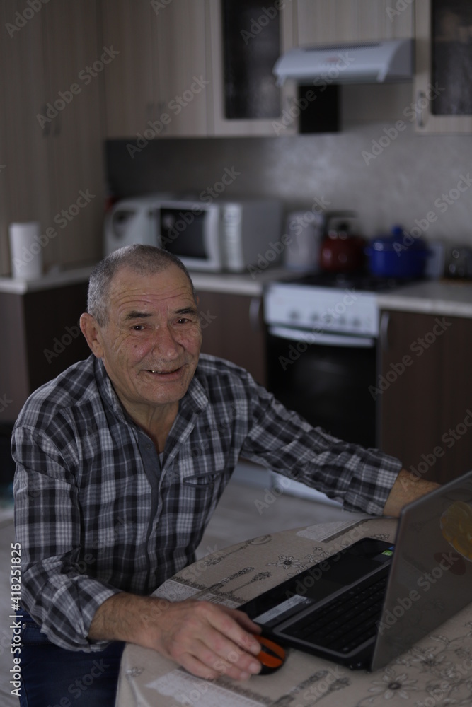 Senior man using laptop whilst smiling Senior man using laptop whilst smiling