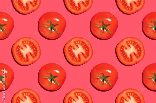 Seamless pattern of whole and cut red tomatoes on a pink background