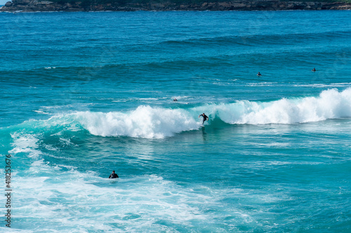 Surfer catching a wave with turquoise coloured water