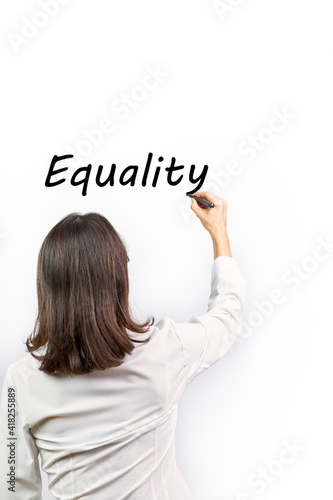 Woman writing the word Equality on white background. Concept feminism © luismicss