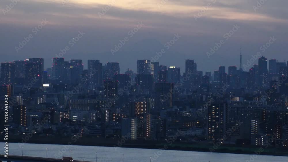 TOKYO, JAPAN : Aerial sunset CITYSCAPE of TOKYO and MOUNT FUJI. View of sun, river and buildings at downtown area. Japanese urban metropolis and nature concept. Time lapse tracking shot dusk to night. TOKYO, JAPAN : Aerial sunset CITYSCAPE of TOKYO and MOUNT FUJI. View of sun, river and buildings at downtown area. Japanese urban metropolis and nature concept. Time lapse tracking shot dusk to night.
