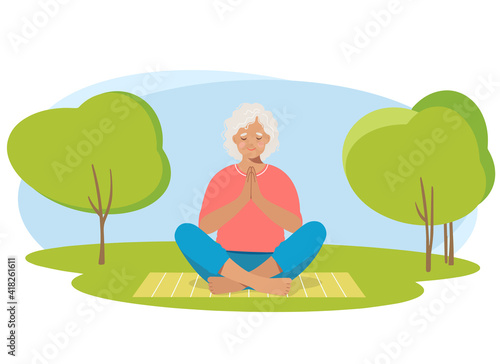 Senior woman meditating and exercising yoga lotus position in nature.