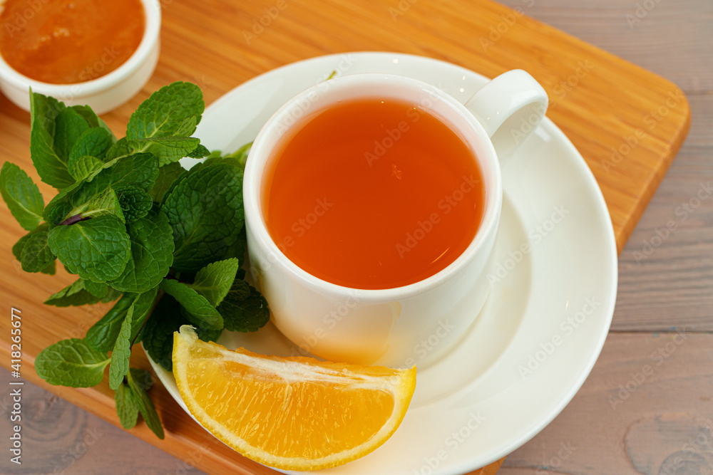 Cup of tea served with lemon and mint Cup of tea served with lemon and mint