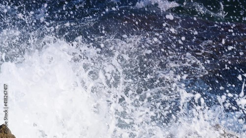 Big waves crashing on the rocks cliff.  Slow motion. View from above