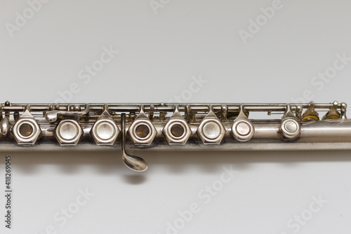 Silvery musical instrument with keys on a white background with soft shadow
