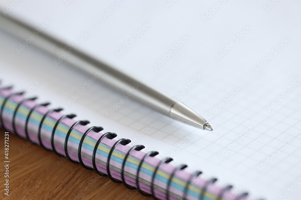 Metal ballpoint pen lying on blank notebook closeup Metal ballpoint pen lying on blank notebook closeup