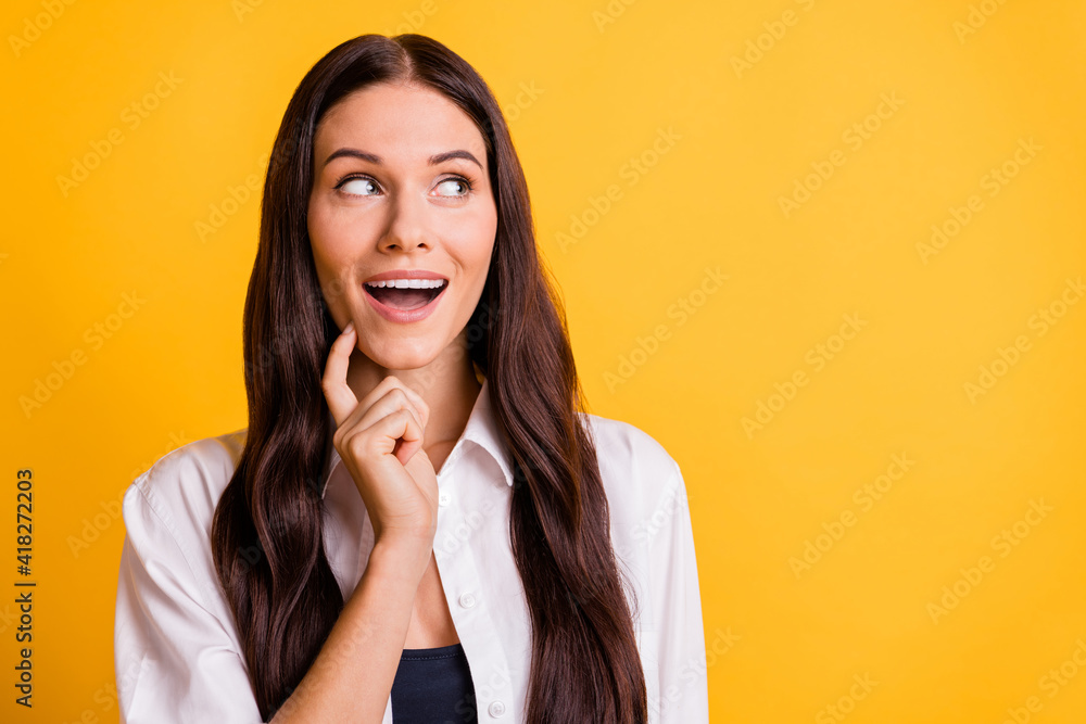 Portrait of cheerful person arm finger on chin open mouth look empty space isolated on yellow color background Portrait of cheerful person arm finger on chin open mouth look empty space isolated on yellow color background