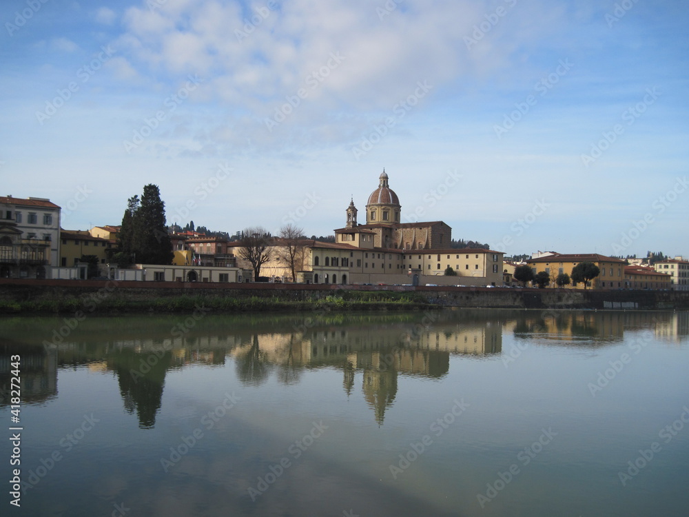 View of the River Arno with historic buildings in the morning. Scenic landscape with old stone building. Travel to European Union. UNESCO World Heritage Site.