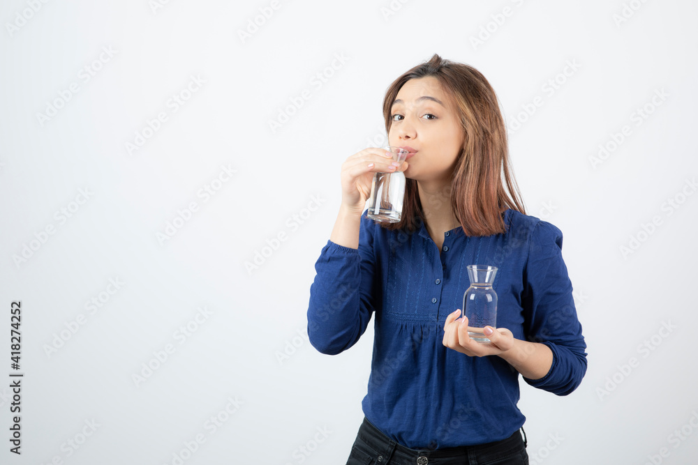 Young woman in blue blouse drinking glass of water Young woman in blue blouse drinking glass of water