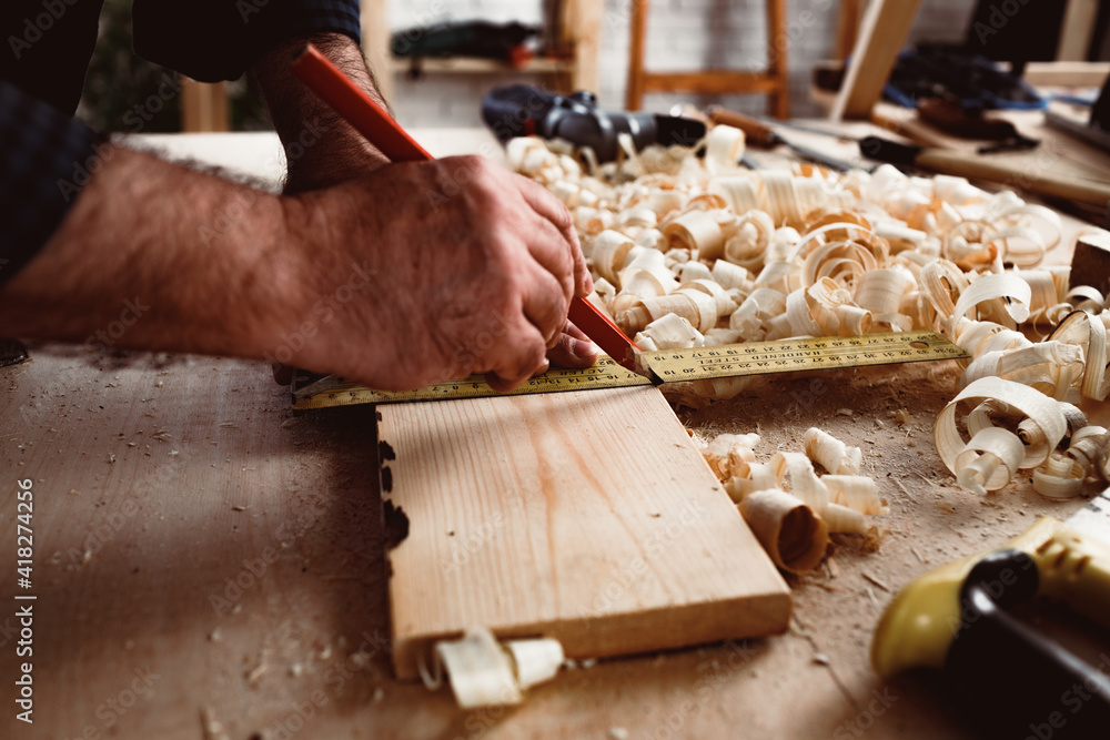 Carpenter makes pencil marks on a wood plank Carpenter makes pencil marks on a wood plank