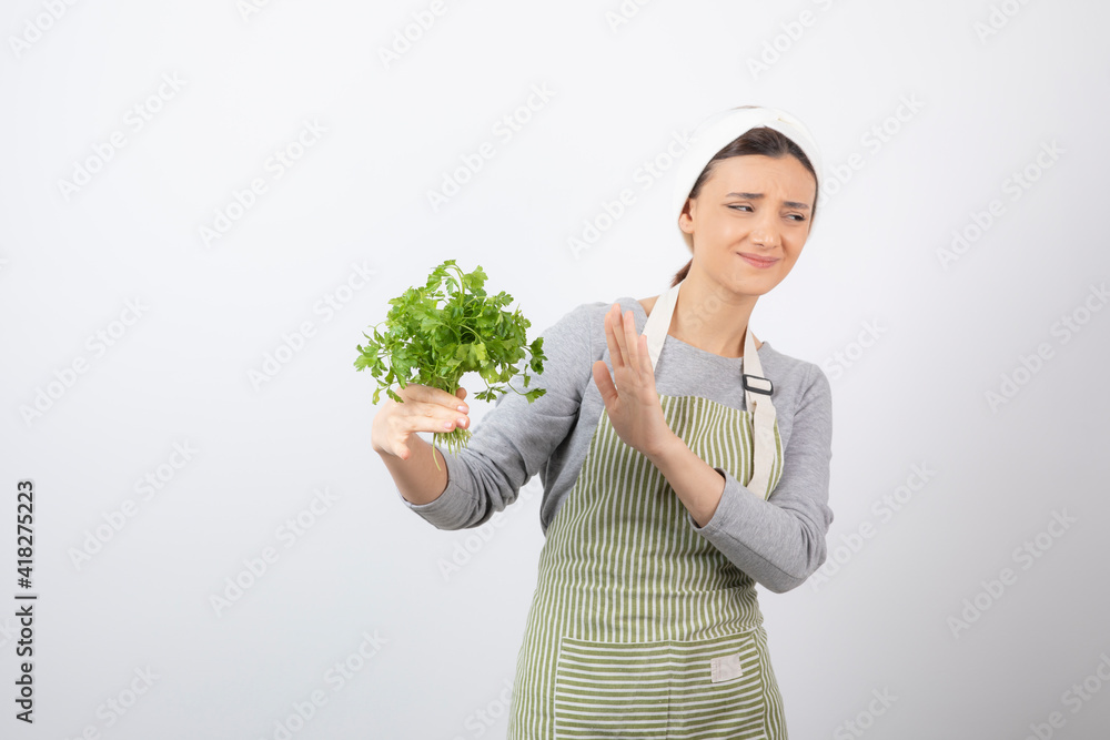 Portrait of a pretty cute woman holding beam of fresh parsley