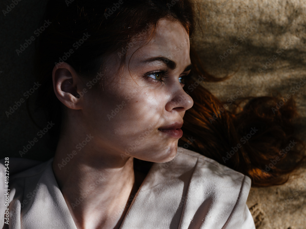 Fototapeta premium Woman lies on the ground outdoors for leisure close-up