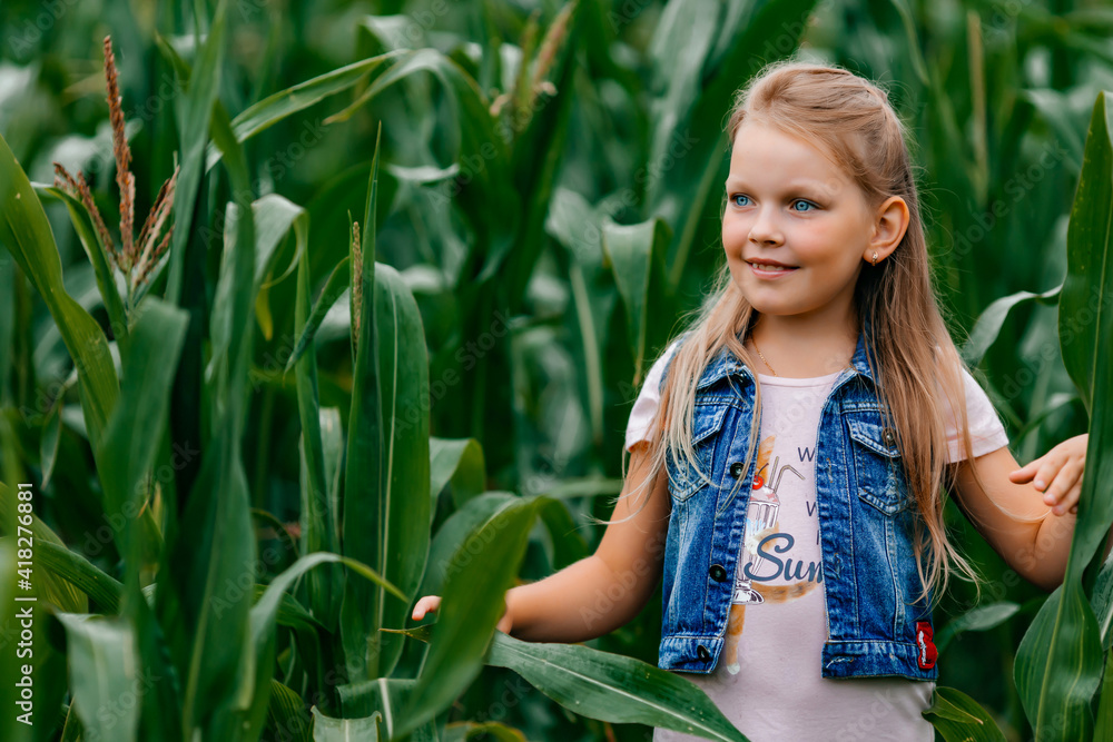 Little cute girl in summer corn leaves, art portrait of a woman in nature. Little cute girl in summer corn leaves, art portrait of a woman in nature.