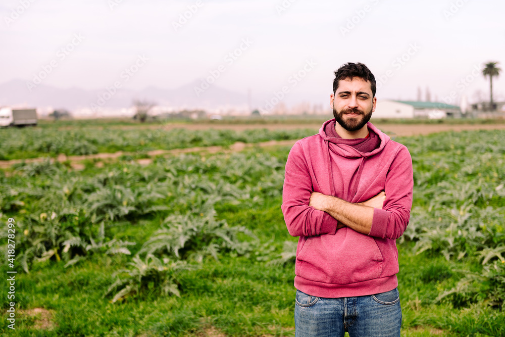 Fototapeta premium young entrepreneur farmer in front of a farm field