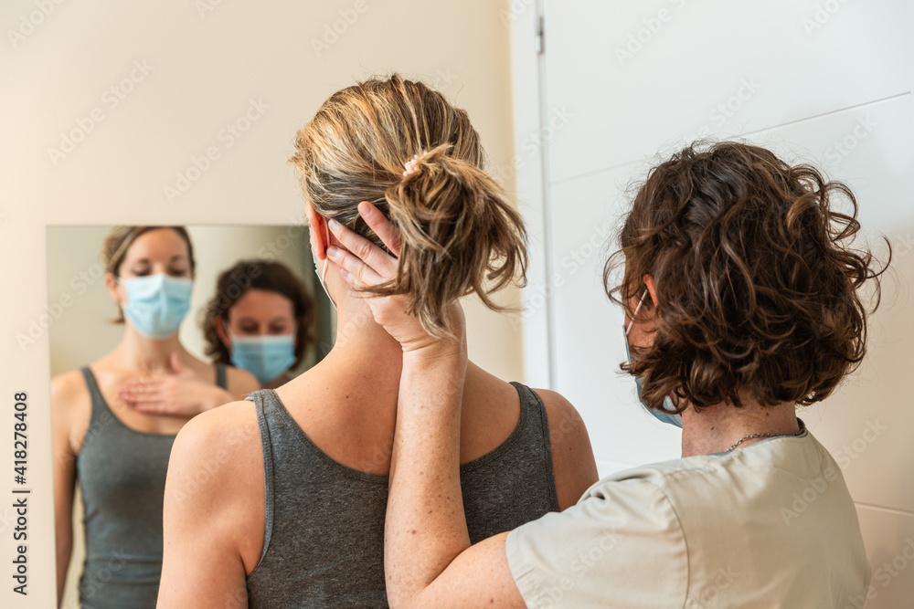 Fototapeta premium Physiotherapist and patient in Global Postural correction session, with pandemic protection mask.