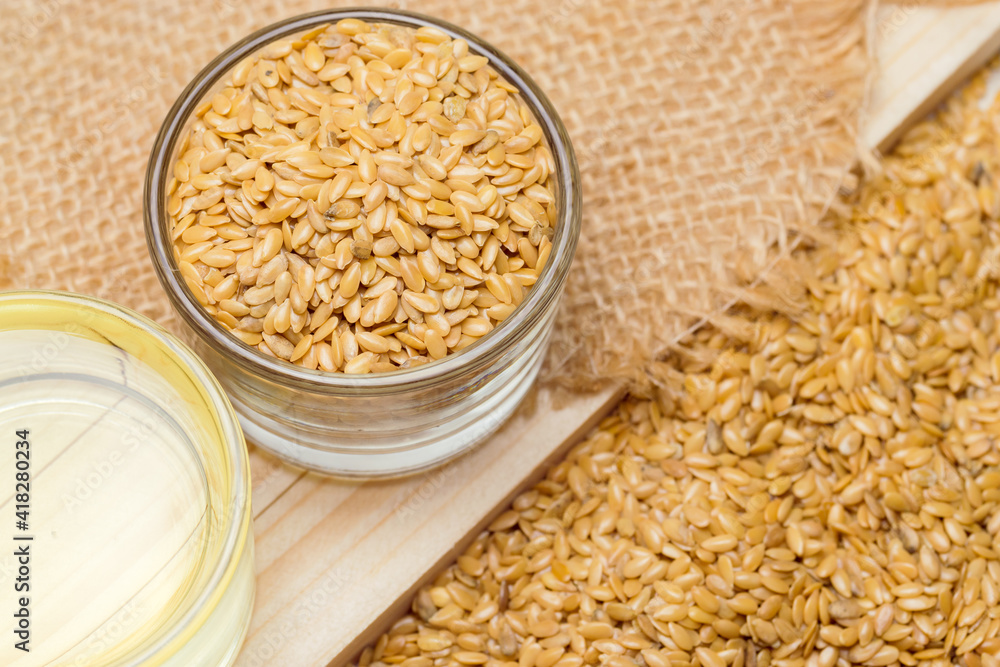 Golden flaxseeds or linseeds, close up with flaxseed oil Golden flaxseeds or linseeds, close up with flaxseed oil