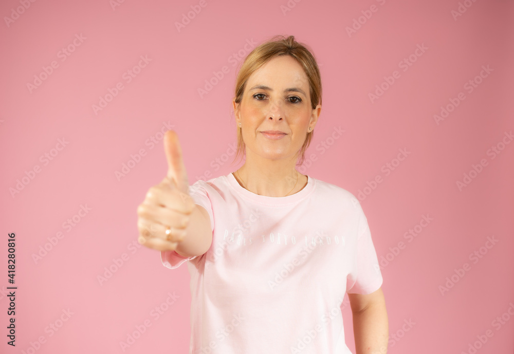 Smiling pretty young woman showing thumb up isolated over pink background Smiling pretty young woman showing thumb up isolated over pink background