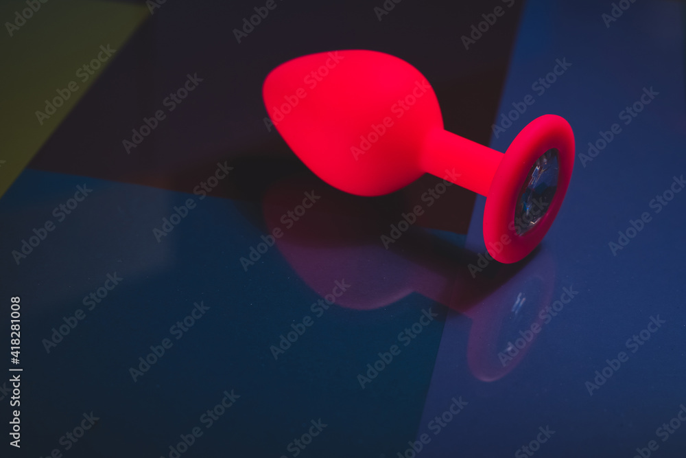 Beautiful smooth pink butt plug or buttplug, sex toy, on a colorful background. Contrast photo of an anal toy on a cool background. Beautiful smooth pink butt plug or buttplug, sex toy, on a colorful background. Contrast photo of an anal toy on a cool background.