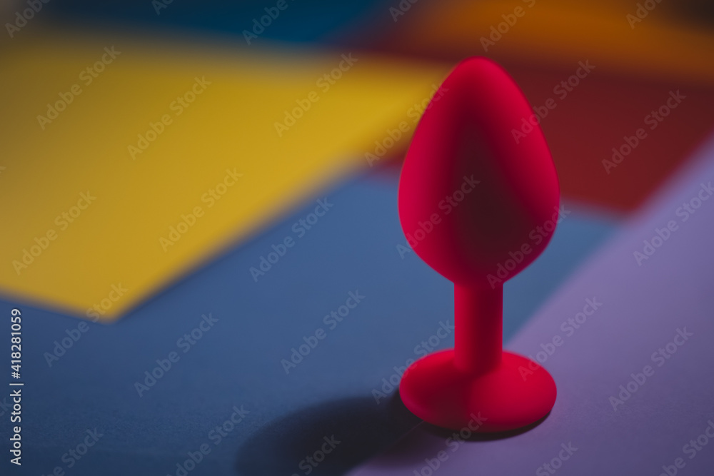 Beautiful smooth pink butt plug or buttplug, sex toy, on a colorful background. Contrast photo of an anal toy on a cool background. Beautiful smooth pink butt plug or buttplug, sex toy, on a colorful background. Contrast photo of an anal toy on a cool background.