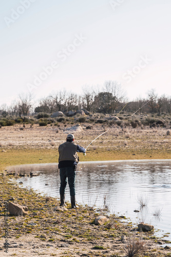 A man casts his fishing rod to catch fish in a lake