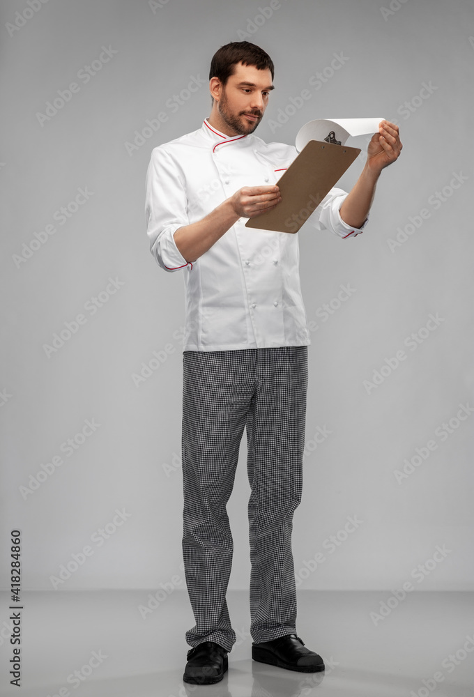 cooking, culinary and people concept - male chef with clipboard and pencil over grey background cooking, culinary and people concept - male chef with clipboard and pencil over grey background
