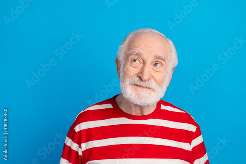 Photo of optimistic old grey hairdo man look empty space wear red t-shirt isolated on bright blue color background
